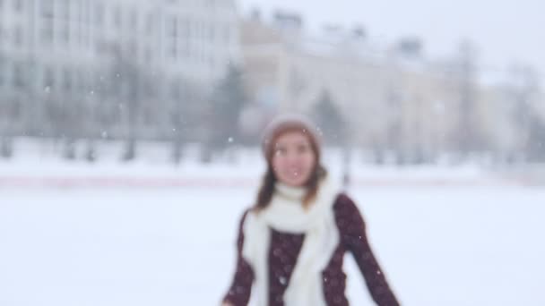 Eine junge lächelnde Frau, die draußen Schlittschuh läuft und sich der Kamera nähert — Stockvideo