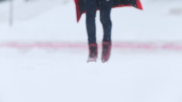 젊은 여 자가 얼음 밖에 서 밝은 빨간 스케이트 스케이트. 눈 덮인 날씨 — 비디오