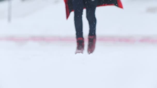 En ung kvinna som skridskoåkning i ljusa röda skridskor utanför. Snöiga väder — Stockvideo