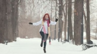 Winter park. Parlak kırmızı saç daha yakın atlama kameraya gülümseyen bir kadınla