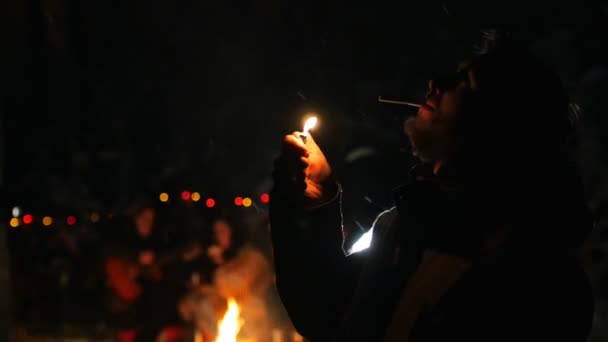 Szakállas férfi téli erdő állt, és a dohányzás. Gyullad a cigaretta — Stock videók