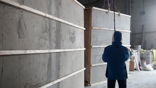 Byggarbetsplatsen. Arbetstagare som skyddar delen av väggen från den fallande — Stockvideo