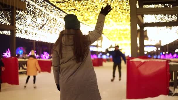 Een jong koppel ontmoet op het ijs rink schaatsen en knuffelen — Stockvideo