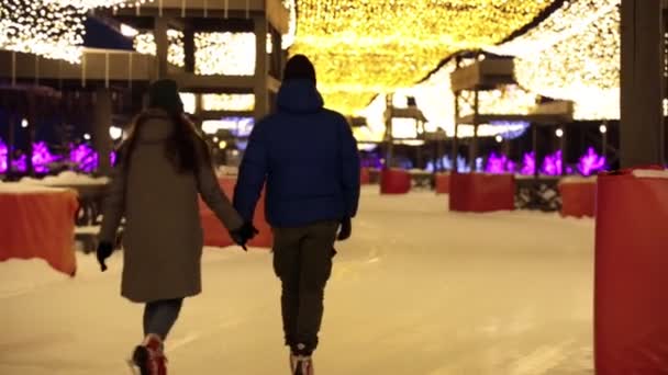 Niedliches junges Paar eislaufend zusammen Händchen haltend — Stockvideo