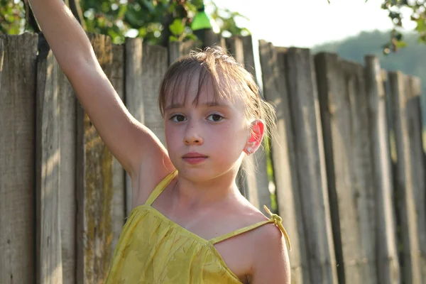 少女は木製フェンス - 夏ロシア村近くサスカトゥーンベリーを食べてください。 — ストック写真