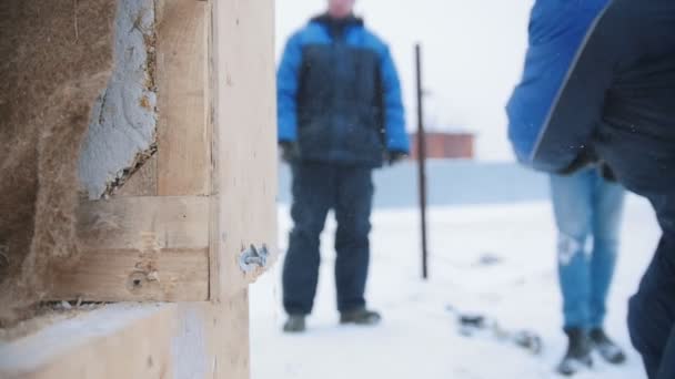Lugar de construcción. Un hombre golpeando una caja de madera con un martillo — Vídeo de stock