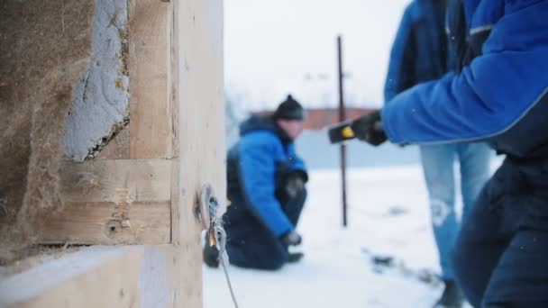 Cantiere. Un uomo che colpisce una scatola di legno con un martello. Un gancio cade dalla scatola — Video Stock