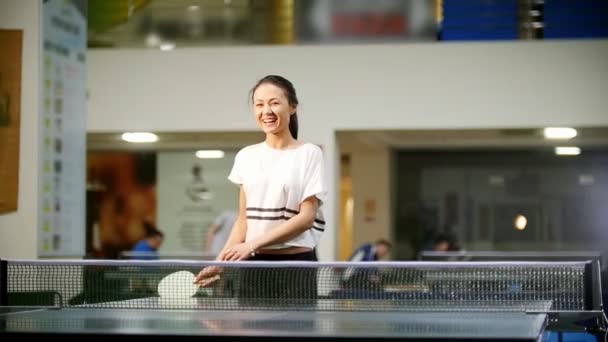 Jugando al ping pong. Joven mujer sonriente jugando tenis de mesa — Vídeo de stock