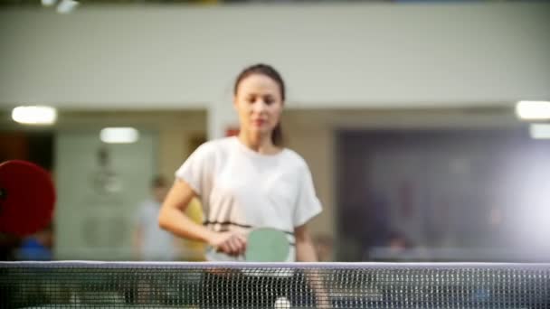 Играет пинг-понг. Молодая женщина играет в настольный теннис и поднимает руки — стоковое видео