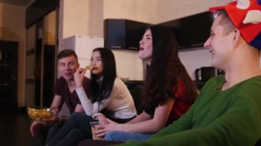 Dört gençler futbol maçı izlerken, abur cubur yemek ve oyun tartışıyor