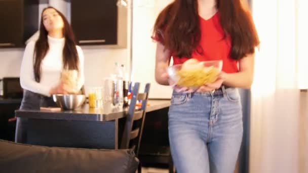 苗条的年轻女子拿着一个装满筹码的碗 去她的朋友在沙发上 — 图库视频影像