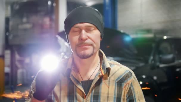 Car-service. Mekaniker mannen i svart hatt stående av bilen håller ett verktyg — Stockvideo