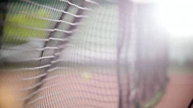 Tenis kortunda eğitim. Izgarayı birkaç kez isabet tenis topları