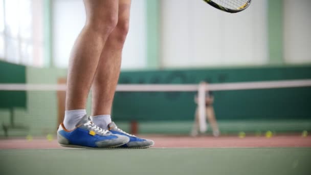 Двоє молодих чоловіків у гарній формі грають у теніс. Ноги в синіх чоботях у фокусі — стокове відео