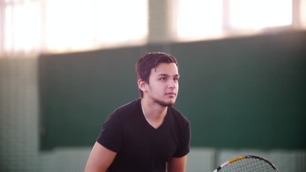 Opleiding op de tennisbaan. Jonge man klaar voor het spel, maar hij krijgt verspreid door tennisballen. Die zichzelf met een raquet — Stockvideo