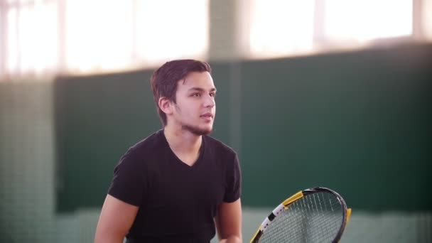 Allenamento sul campo da tennis. Giovane uomo viene sparso da palle da tennis. Si coprì con un raquet — Video Stock