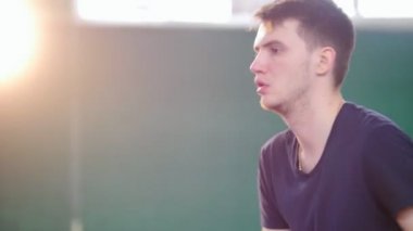 Tenis kortunda eğitim. Genç adam tenis oynamaya konsantre