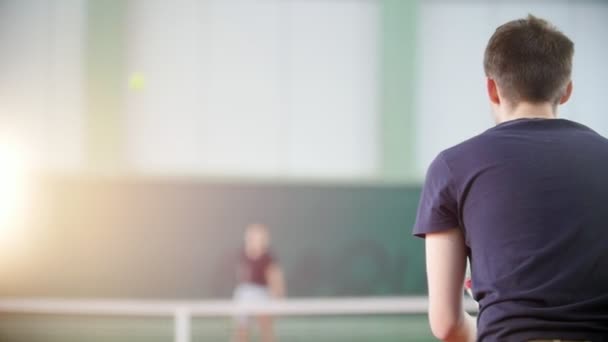 テニスコートでトレーニング。テニスをして 2 人の若者。背面図 — ストック動画