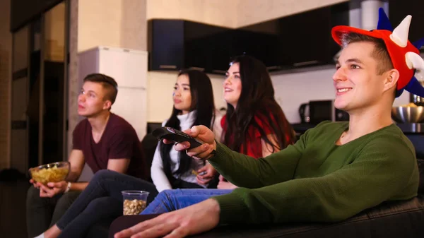 Cuatro Jóvenes Sentados Sofá Viendo Partido Fútbol Hombre Sosteniendo Tele —  Fotos de Stock