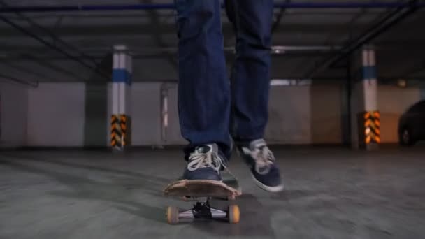 Un joven patinando en su tabla con colores militares en el estacionamiento. Patinaje hacia la cámara — Vídeos de Stock