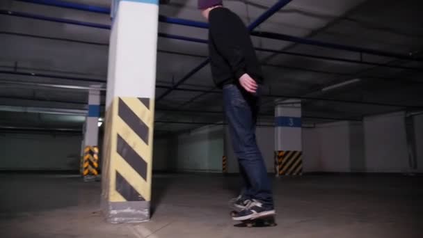 Un jeune homme skateboard à l'intérieur du parking — Video