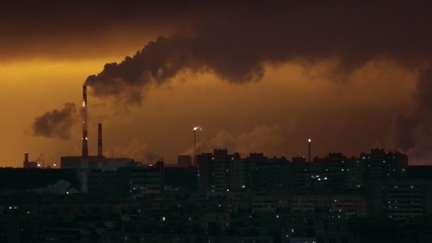 Conceito industrial. Filas de edifícios. Os tubos industriais exalam o fumo. Luzes das janelas — Vídeo de Stock