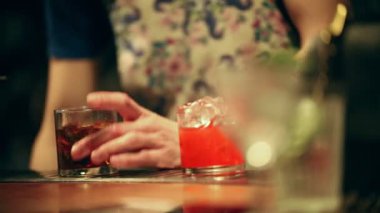 Barmen çalışıyor. Bir alkollü kokteyl cam karıştırma. Bir buz ekleme