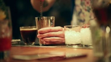 Barmen çalışıyor. Bir bardak buz dolu. Kokteyl shaker bir kaşık kullanarak karışımı barmen