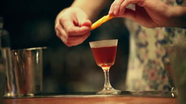 Bartender working. Decorating an alcoholic cocktail in the glass — Stock Video