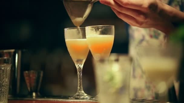 Empregado a trabalhar. Misturar um cocktail alcoólico no copo. Peneire o ingrediente por uma peneira — Vídeo de Stock