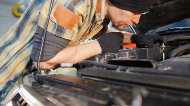 Araba servisi. Tamirci adam aşağı doğru motor görevini yerine getirmektedir. Bir araba tamiri.