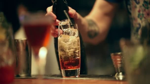 调酒师在工作在杯子里混合一杯酒精鸡尾酒。添加气泡, 与勺子混合, 并完成服务 — 图库视频影像