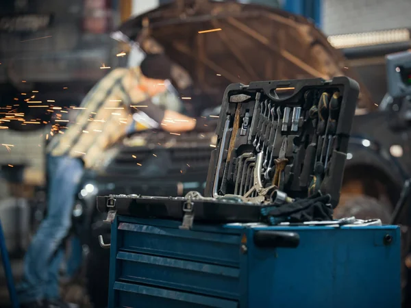 Araba servisi. Tamirci adam bir araç tutarak ve kamera seyir arabanın yanında ayakta