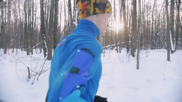 Joven hombre y mujer corriendo en el bosque de invierno por la mañana temprano. Vista lateral — Vídeos de Stock