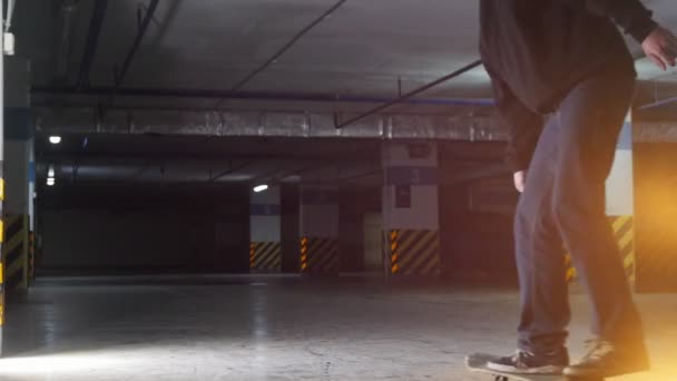 Parking souterrain. Un jeune homme qui skate. Former ses compétences — Video
