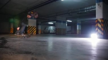 Yeraltı otoparkına. Kaykay genç bir adam. Ollie hüner pratik