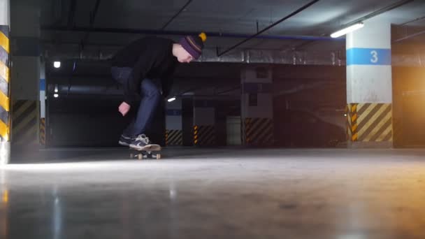 Parking podziemny. Młody człowiek, skateboarding. Praktykowanie skomplikowany podstęp — Wideo stockowe