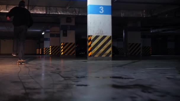 Földalatti parkoló. Egy fiatal férfi, gyakorló, gördeszka — Stock videók