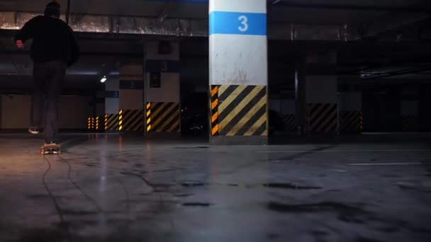 Aparcamiento subterráneo. Un joven practicando skate — Vídeo de stock