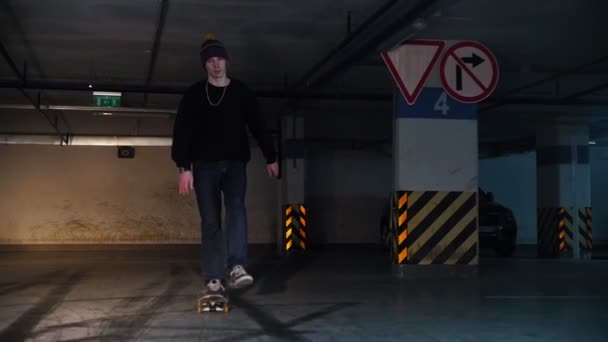 Parking souterrain. Un jeune homme pratiquant le skateboard. Patiner vers la caméra — Video