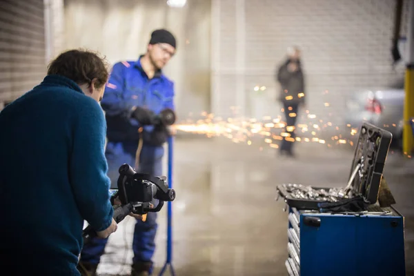 Servizio di riparazione auto. Dietro le quinte delle riprese. Fare scintille con una rettificatrice — Foto Stock