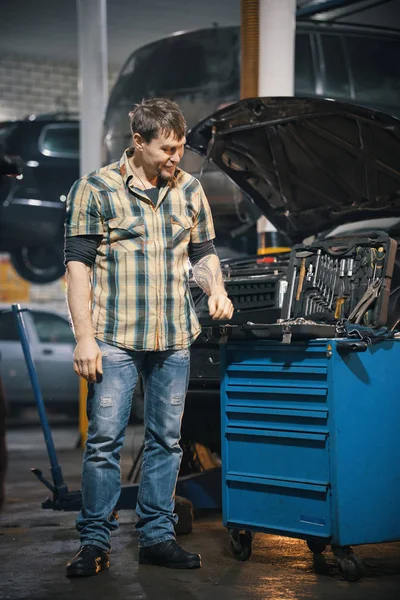 Servicio de coches. Hombre mecánico de pie junto a una caja de herramientas — Foto de Stock