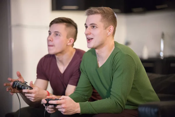 Compañía de jóvenes amigos pasando tiempo juntos. Dos jóvenes jugando juego —  Fotos de Stock