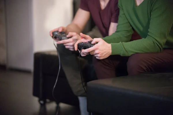 Dois jovens jogando jogos segurando um joysticks — Fotografia de Stock