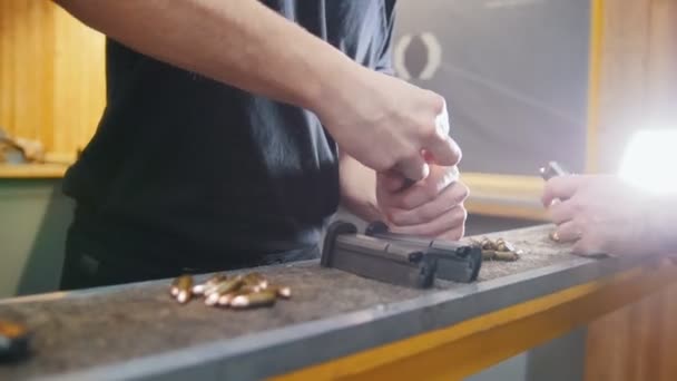 Shooting gallery. A young man charge the cartridge clip — Stock Video