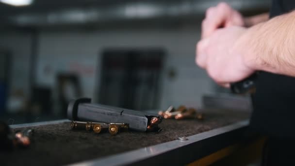 Schießbude. ein junger Mann bereitet die Waffe für die Schüsse vor — Stockvideo