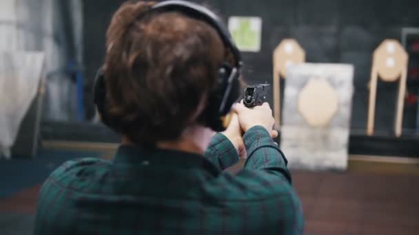 Shooting gallery. A young man getting the comfortable position for shooting — Stock Video