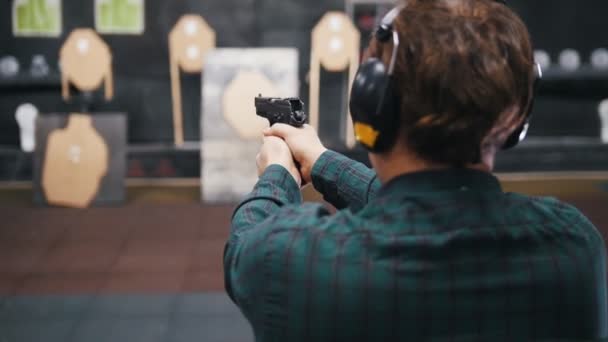 Galeria de tiro. Um jovem atirando em um campo de tiro — Vídeo de Stock