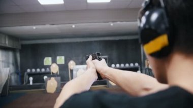 Atış poligonu. Genç bir adam bir silah ile çekim kulaklık. Bir delil