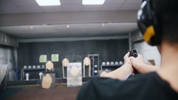 Shooting gallery. Ένας νεαρός άνδρας, πυροβολισμός με τα πυροβόλα όπλα. Στοχεύοντας σε έναν στόχο — Αρχείο Βίντεο